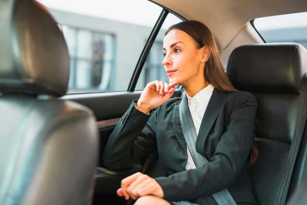 businesswoman-looking-through-window-while-traveling-by-car_23-2147943876